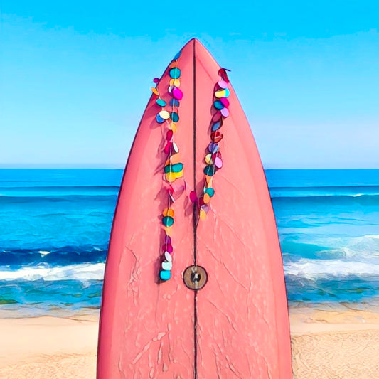 A fridge magnet pink surfboard overlooking the surf beach