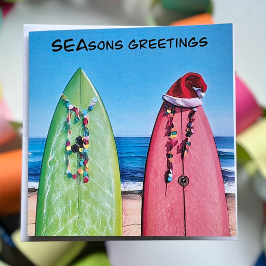 Two surfboards with a santa hat on the beach chistmas greeting card with envelope 