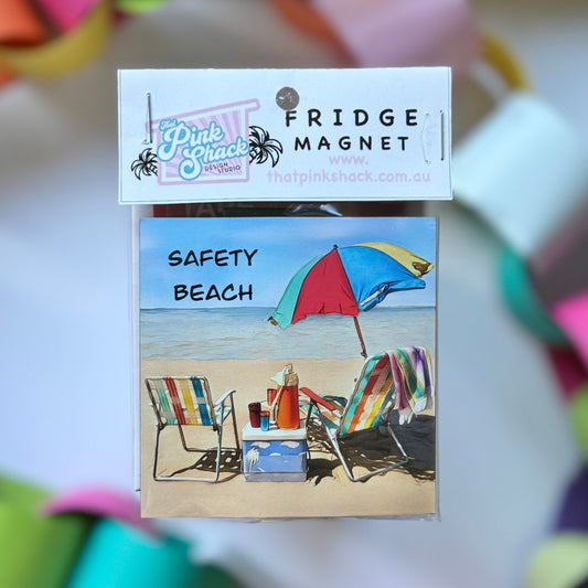 A fridge magnet of safety beach on the mornington peninsula with a vintage beach umbrella and chairs in packaging